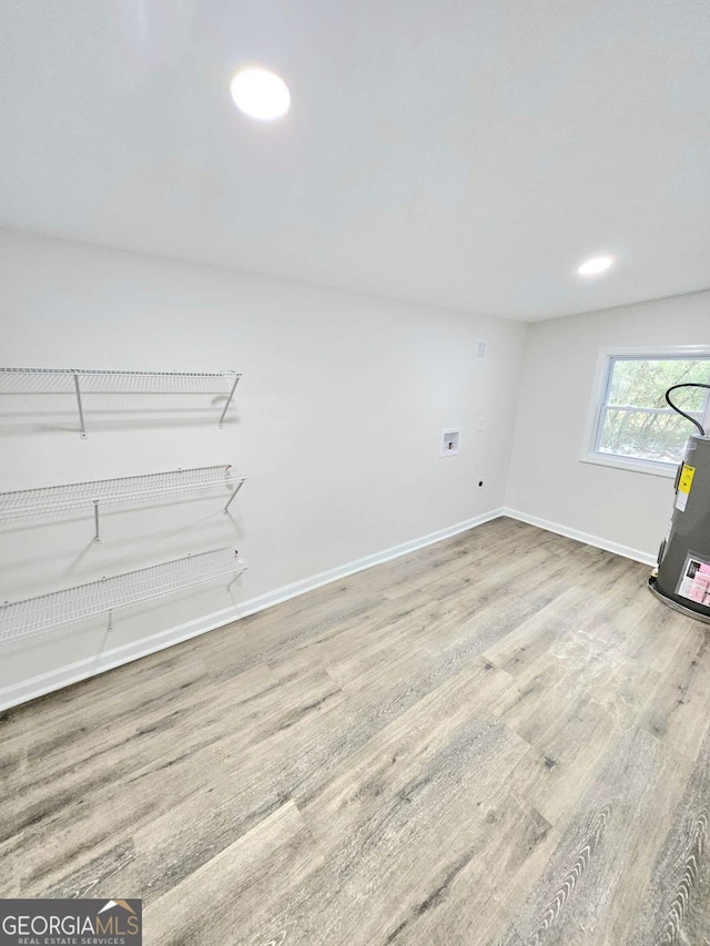 interior space with hardwood / wood-style flooring and electric water heater