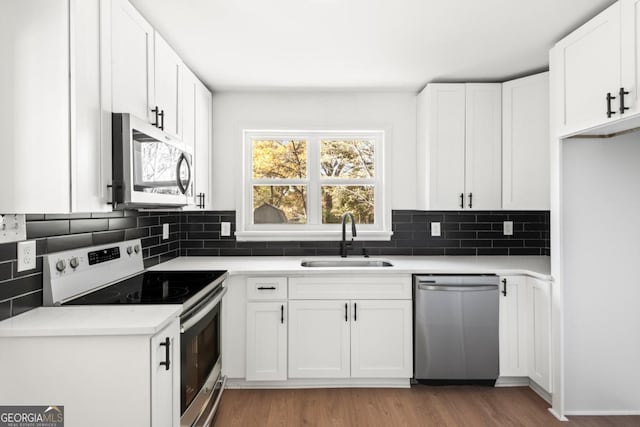 kitchen featuring white cabinets, decorative backsplash, sink, and stainless steel appliances