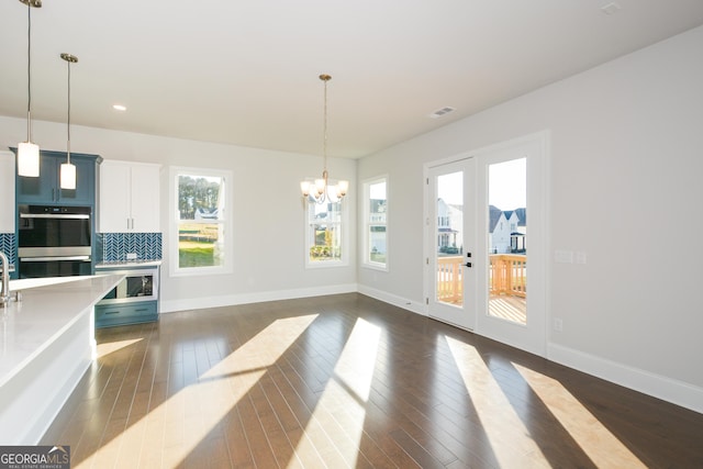 dining space with french doors, an inviting chandelier, and dark wood-type flooring