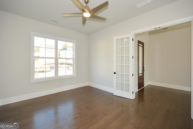 empty room featuring ceiling fan, french doors, and dark wood-type flooring