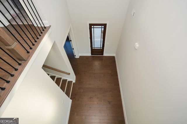 entryway featuring a towering ceiling and dark hardwood / wood-style floors