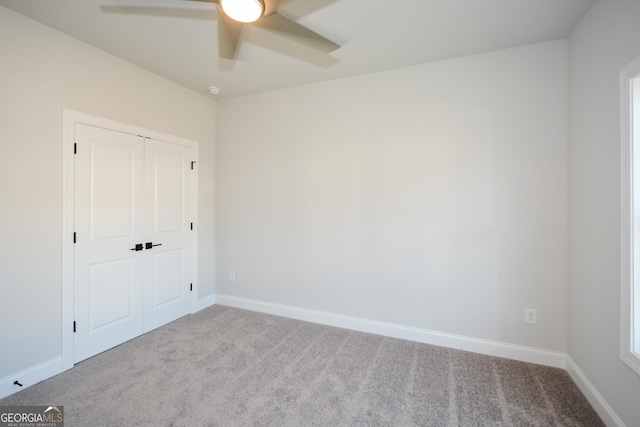 unfurnished room with ceiling fan and light colored carpet