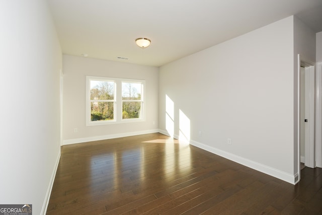 empty room with dark hardwood / wood-style flooring