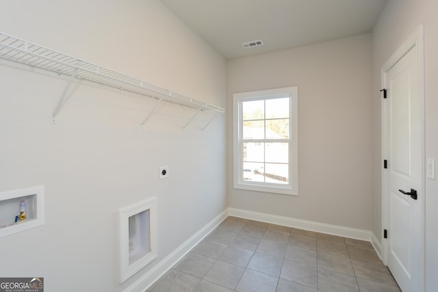 clothes washing area featuring washer hookup, electric dryer hookup, and light tile patterned flooring