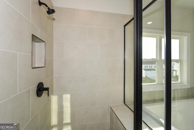 bathroom with tiled shower and a healthy amount of sunlight