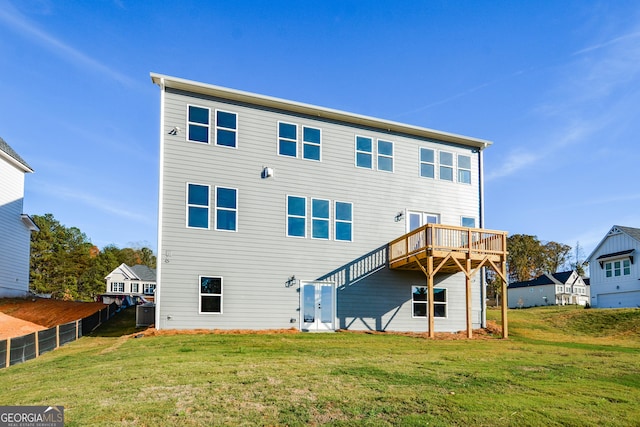 rear view of house featuring a lawn, a wooden deck, and central AC