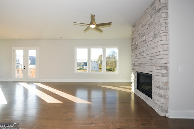 unfurnished living room featuring ceiling fan, a fireplace, and dark hardwood / wood-style floors