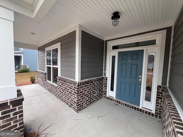 doorway to property featuring covered porch