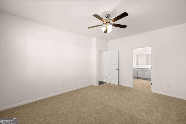 unfurnished bedroom featuring ceiling fan, light colored carpet, and connected bathroom