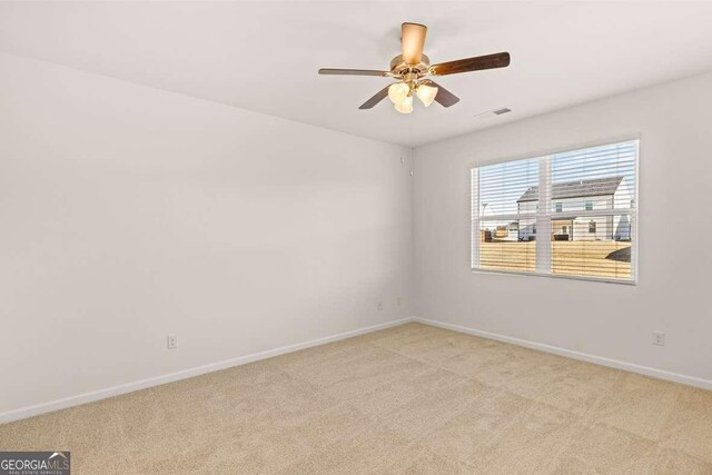 carpeted spare room with ceiling fan