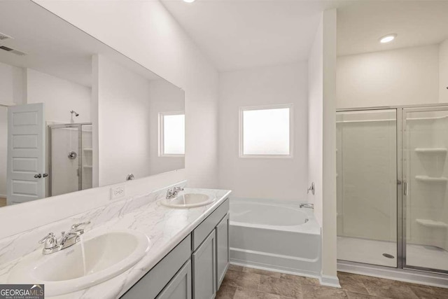 bathroom featuring shower with separate bathtub and vanity