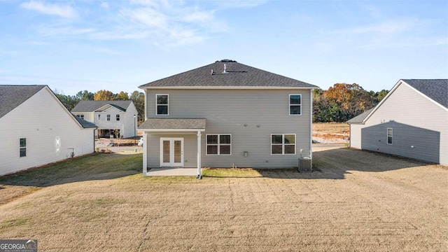 rear view of house featuring a lawn, central AC, french doors, and a patio