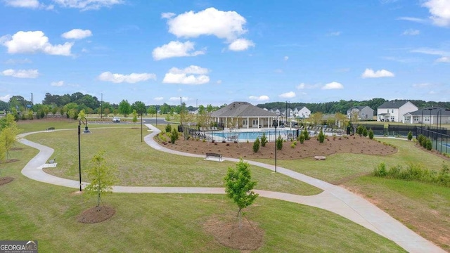 view of property's community featuring a pool and a lawn