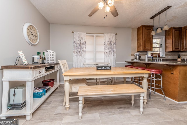 dining area with a textured ceiling, ceiling fan, and sink