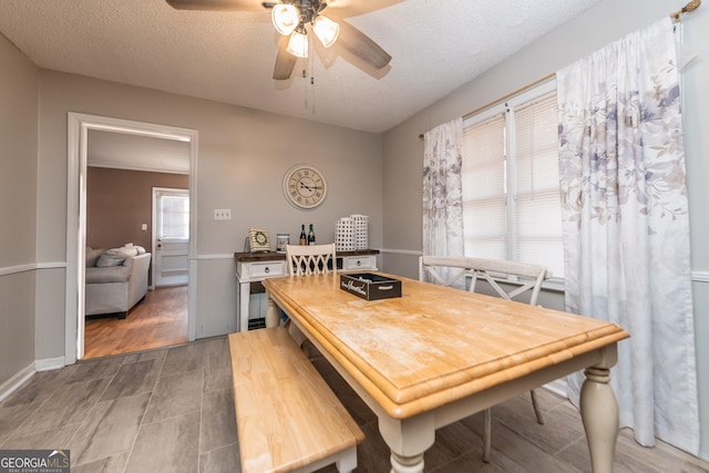 dining space with ceiling fan and a textured ceiling