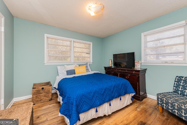 bedroom featuring hardwood / wood-style floors and a textured ceiling