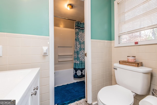 full bathroom featuring vanity, toilet, tile walls, and shower / bath combo with shower curtain