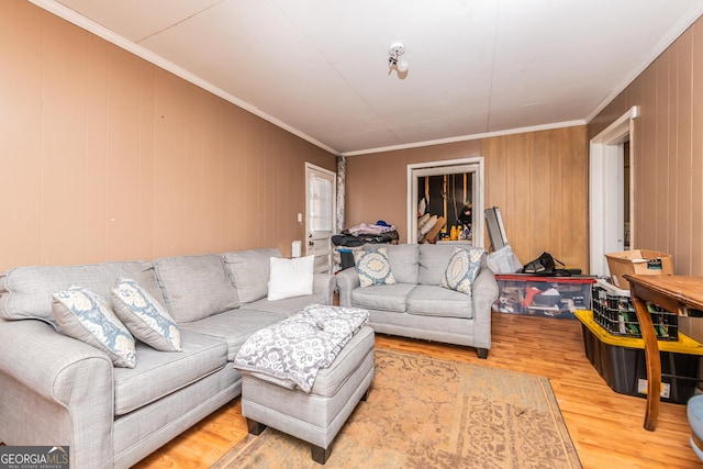 living room with hardwood / wood-style floors, wooden walls, and ornamental molding