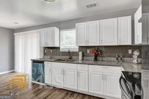 kitchen featuring stove, dark hardwood / wood-style flooring, stainless steel dishwasher, sink, and white cabinetry