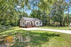 view of front of home with a deck and a front yard