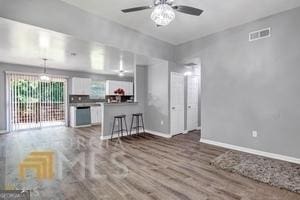 living room with ceiling fan and dark wood-type flooring