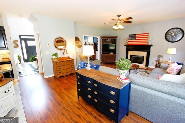 living room featuring dark hardwood / wood-style flooring and ceiling fan