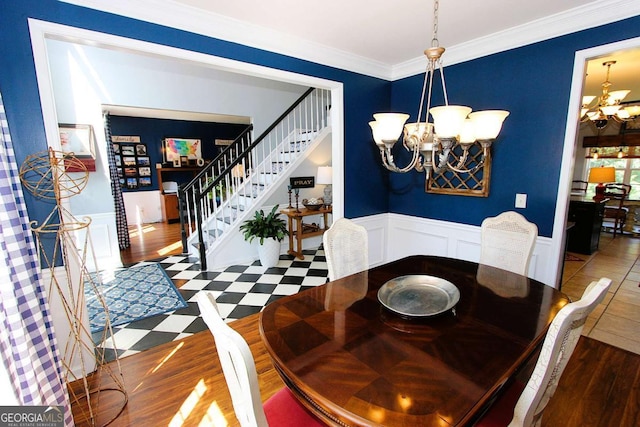 dining space featuring dark hardwood / wood-style flooring, an inviting chandelier, and ornamental molding