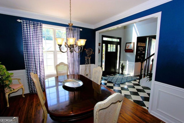 dining area with dark hardwood / wood-style floors, ornamental molding, and a chandelier