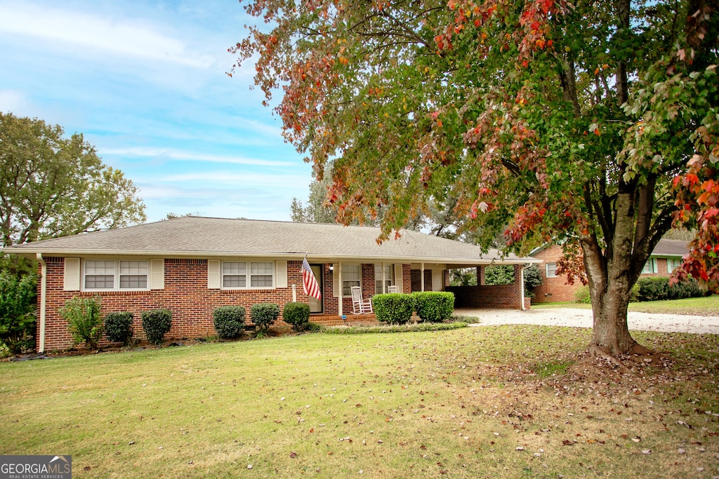 single story home with a front lawn and a carport