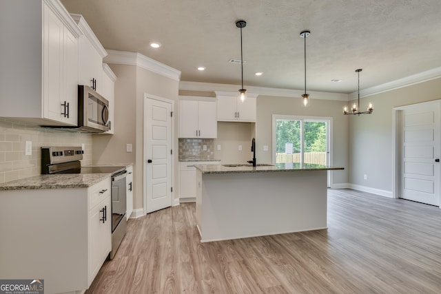 kitchen with white cabinetry, stainless steel appliances, tasteful backsplash, an island with sink, and pendant lighting