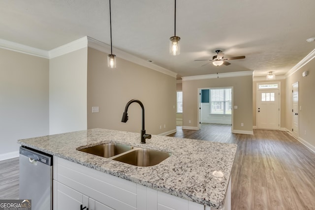 kitchen featuring white cabinets, stainless steel dishwasher, hanging light fixtures, and sink