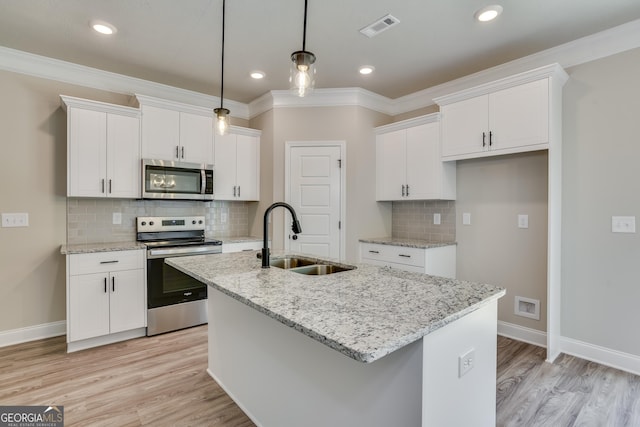 kitchen with a center island with sink, sink, white cabinets, and stainless steel appliances