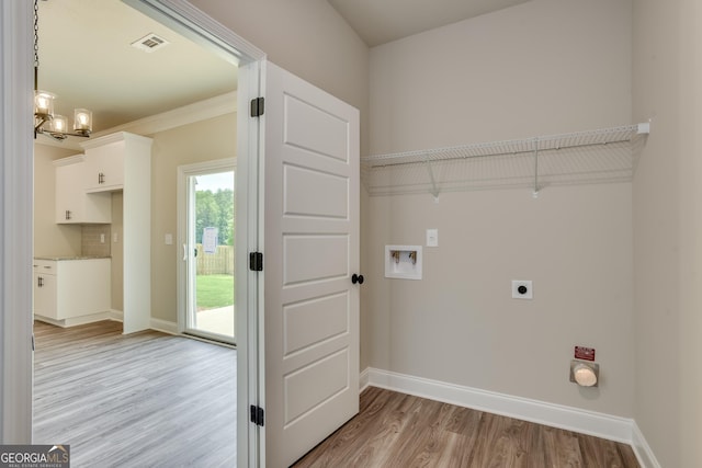 clothes washing area with washer hookup, crown molding, electric dryer hookup, light hardwood / wood-style flooring, and a notable chandelier