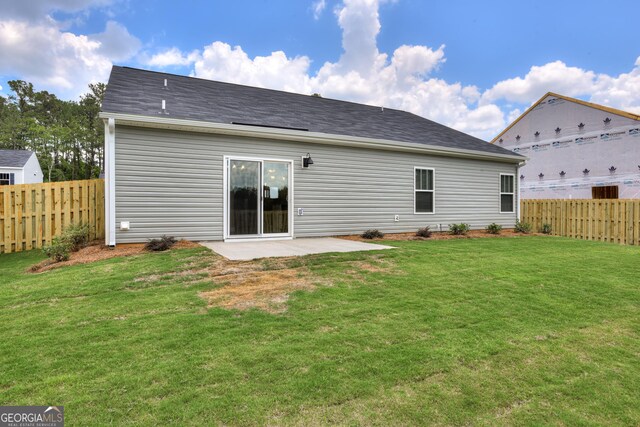 rear view of property with a yard and a patio