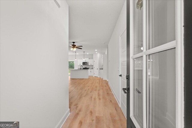 doorway to outside featuring light hardwood / wood-style floors and crown molding