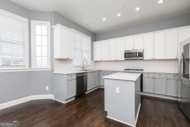 kitchen featuring sink, a center island, dark hardwood / wood-style floors, and appliances with stainless steel finishes