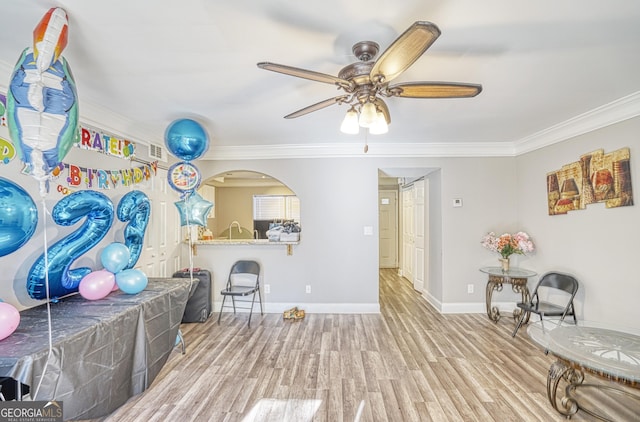 interior space with ceiling fan, hardwood / wood-style floors, and ornamental molding