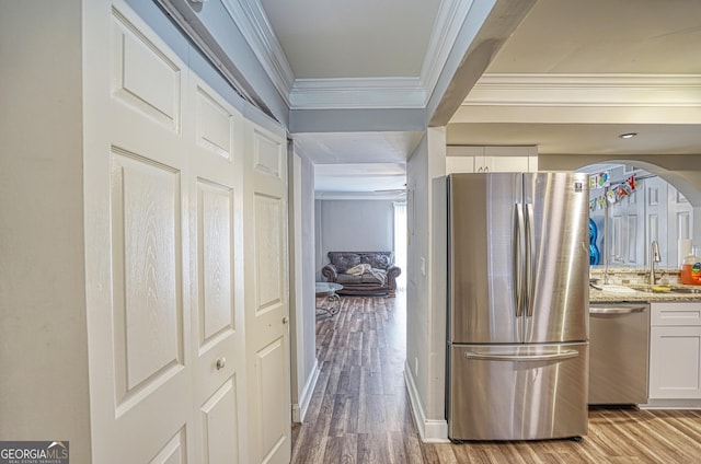 kitchen featuring light stone countertops, stainless steel appliances, ceiling fan, light hardwood / wood-style floors, and white cabinetry