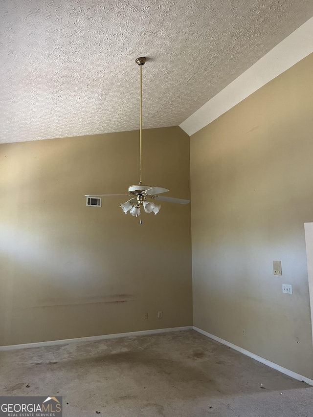 empty room with ceiling fan, a textured ceiling, and vaulted ceiling