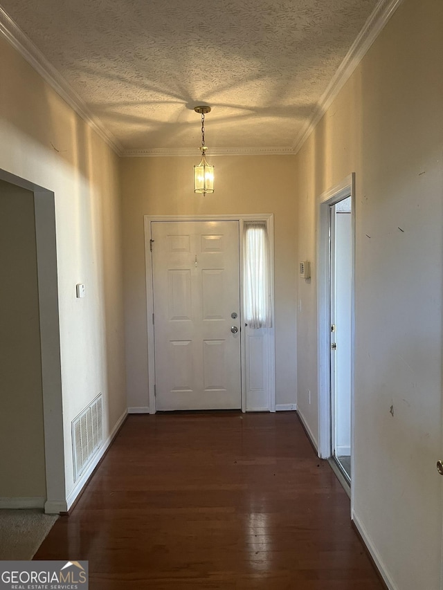 entryway with a chandelier, crown molding, a textured ceiling, and dark wood-type flooring