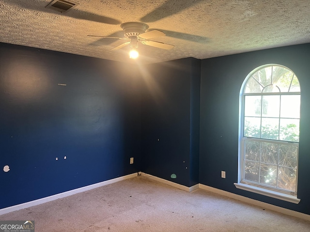 carpeted empty room with ceiling fan and a textured ceiling