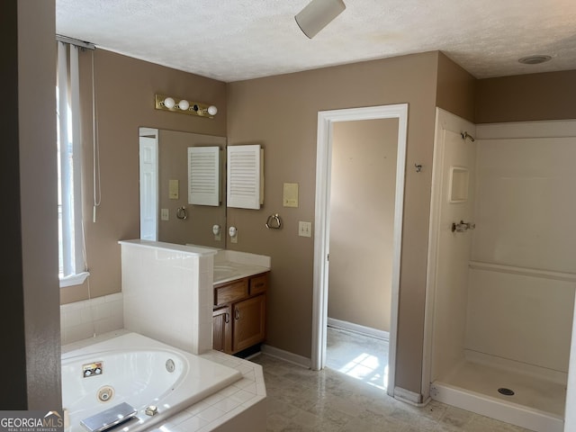 bathroom featuring separate shower and tub, vanity, and a textured ceiling