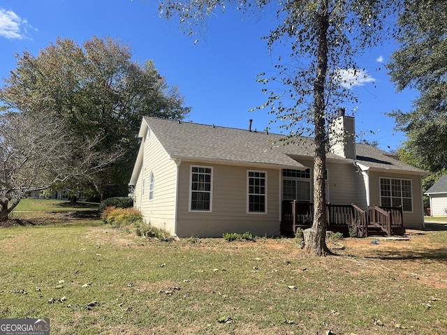 view of front of property with a deck and a front lawn