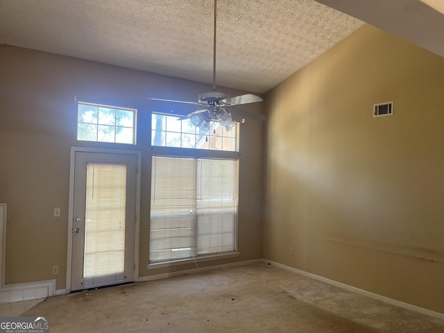 unfurnished dining area featuring ceiling fan, a textured ceiling, high vaulted ceiling, and light carpet