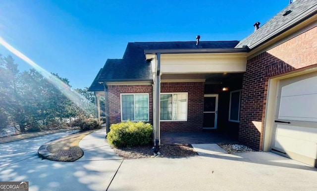 view of exterior entry featuring brick siding