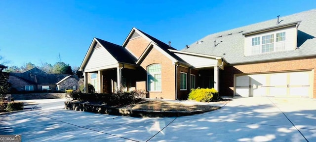 view of front of house with brick siding, driveway, and a garage