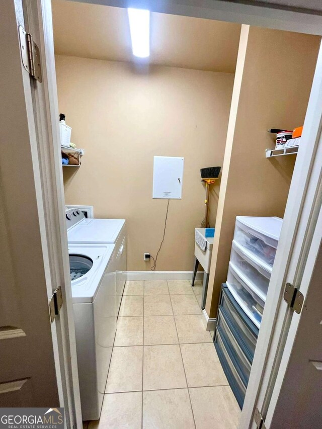 washroom featuring washing machine and dryer and light tile patterned floors