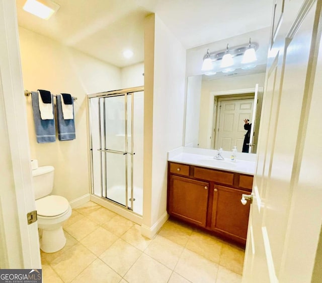 bathroom featuring walk in shower, vanity, toilet, and tile patterned flooring