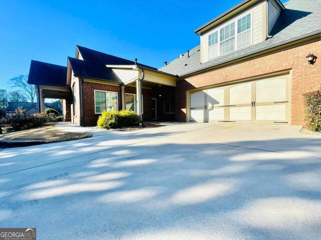 4140 Lanier Ridge Walk Unit 104, Cumming, GA 30041 - view of front of property featuring brick siding, concrete driveway, and a shingled roof