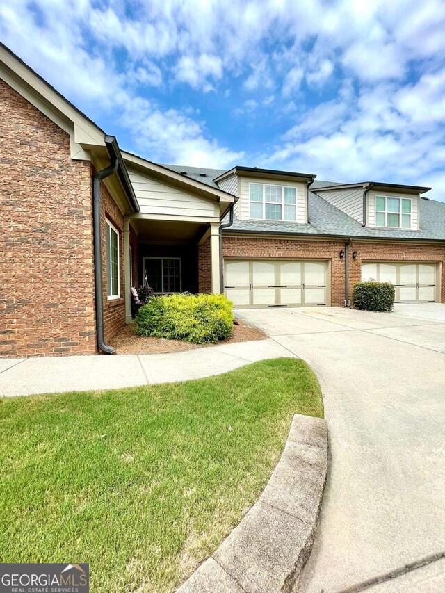 4140 Lanier Ridge Walk Unit 104, Cumming, GA 30041 - townhome / multi-family property featuring driveway, brick siding, and a front yard